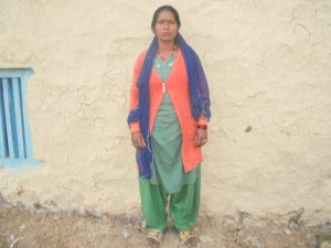 Seema standing in front of her home